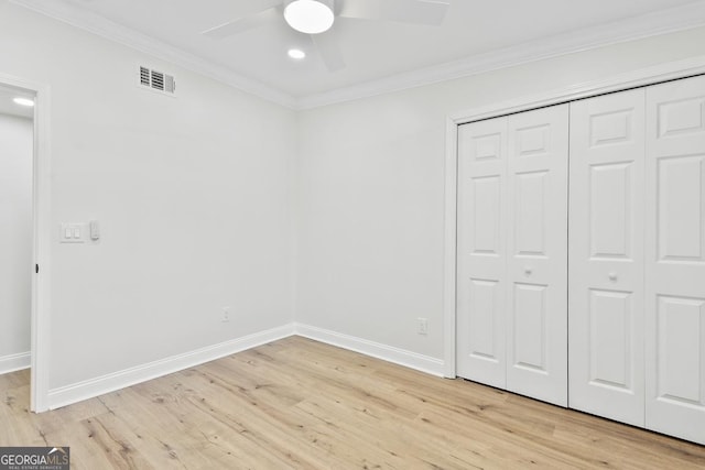 unfurnished bedroom featuring a closet, light hardwood / wood-style flooring, ceiling fan, and crown molding