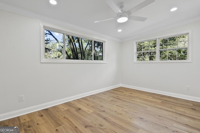 empty room featuring ceiling fan, light hardwood / wood-style floors, a healthy amount of sunlight, and crown molding