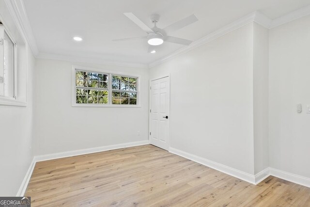 spare room featuring light wood-type flooring, ceiling fan, and ornamental molding