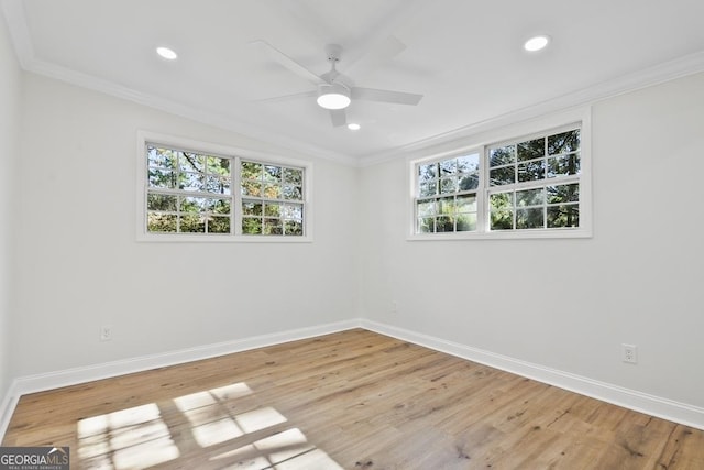 empty room with wood-type flooring, a wealth of natural light, crown molding, and ceiling fan