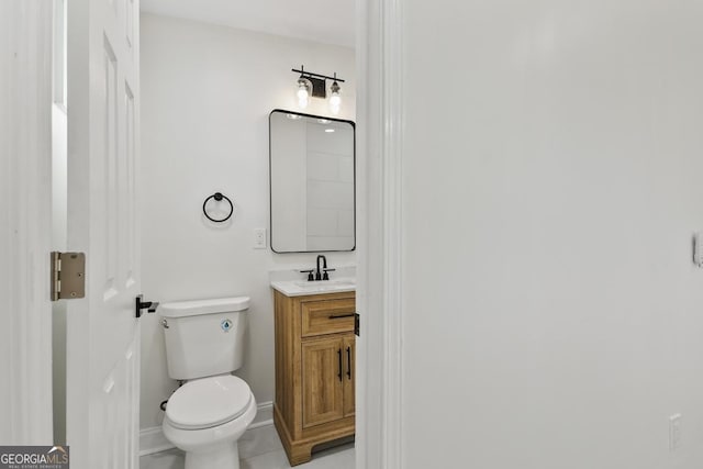 bathroom with tile patterned flooring, vanity, and toilet