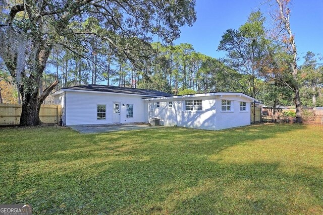 back of house featuring a patio, cooling unit, and a lawn