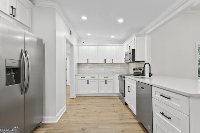 kitchen with sink, appliances with stainless steel finishes, tasteful backsplash, light hardwood / wood-style floors, and white cabinetry