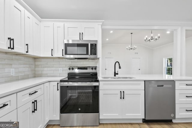 kitchen featuring white cabinetry, sink, a notable chandelier, backsplash, and appliances with stainless steel finishes