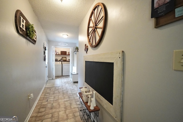 hall with washing machine and dryer and a textured ceiling