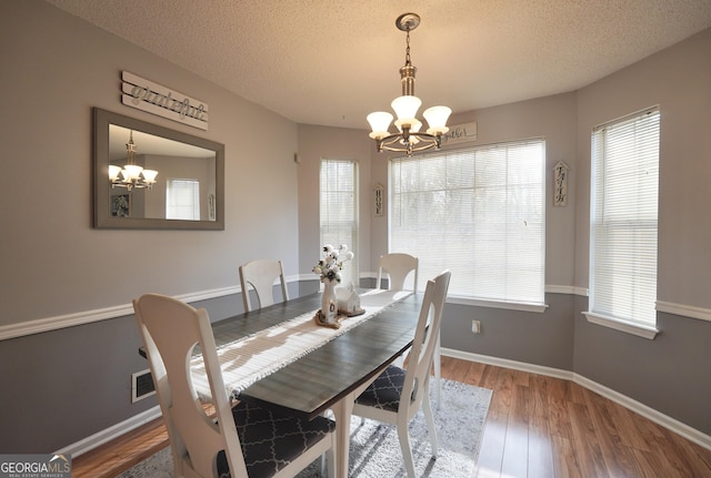 dining room featuring hardwood / wood-style flooring, an inviting chandelier, and plenty of natural light