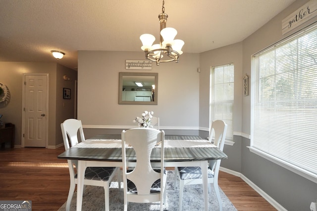 dining room featuring hardwood / wood-style floors, a notable chandelier, and a textured ceiling