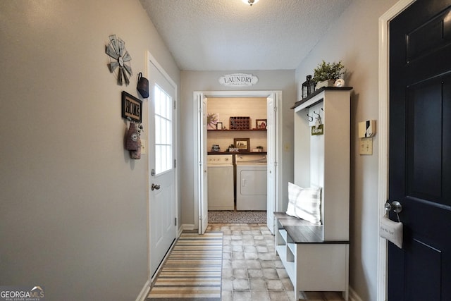 entryway featuring washer and clothes dryer and a textured ceiling