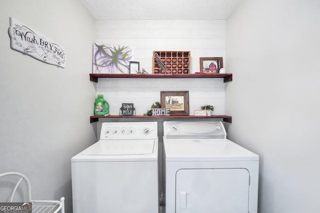 laundry area featuring a textured ceiling and washing machine and dryer