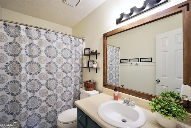 bathroom featuring vanity, toilet, and a textured ceiling