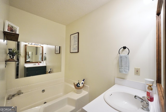 bathroom featuring vanity, a textured ceiling, and a bathtub