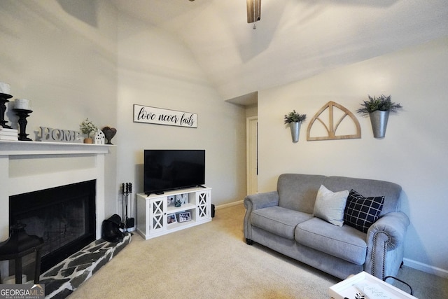 carpeted living room with ceiling fan and vaulted ceiling