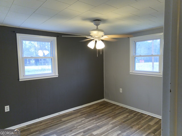 spare room with dark wood-style floors, ceiling fan, and baseboards