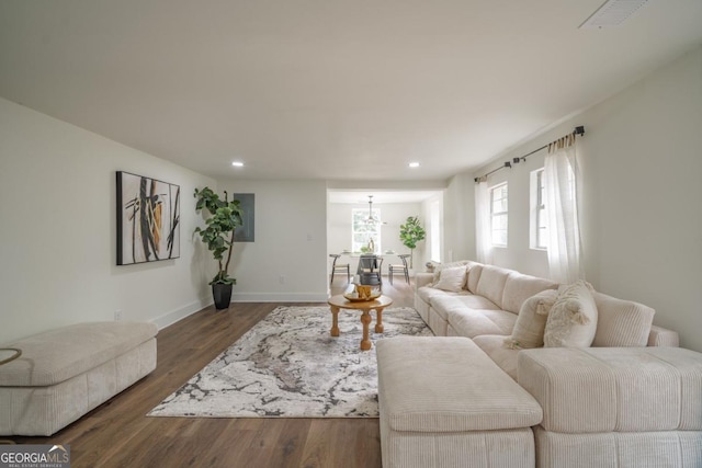 living room with a notable chandelier and dark wood-type flooring