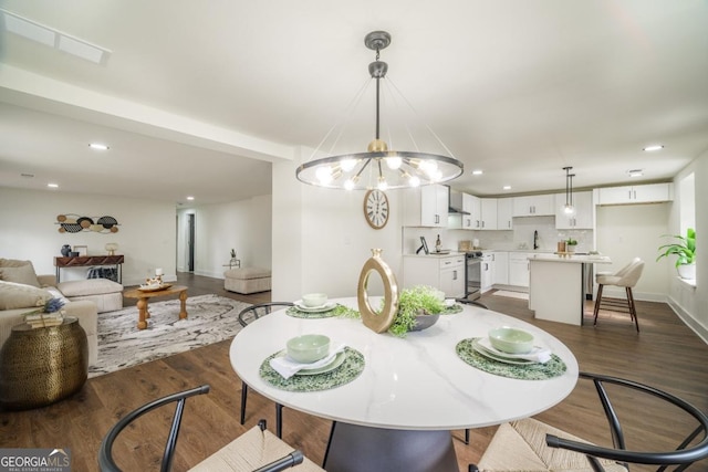 dining room with sink, dark hardwood / wood-style floors, and an inviting chandelier