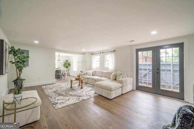 living room with a wealth of natural light, french doors, and hardwood / wood-style floors