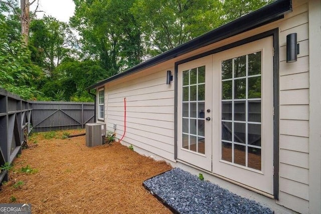 view of home's exterior with central air condition unit and french doors