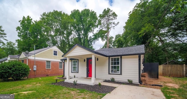 ranch-style home featuring a front lawn and covered porch