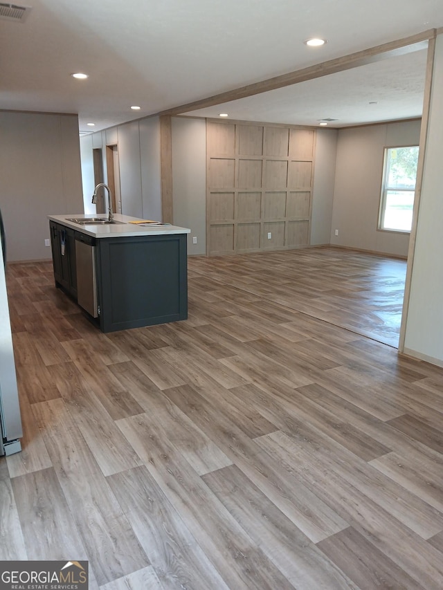 kitchen with a center island with sink, light hardwood / wood-style floors, and sink