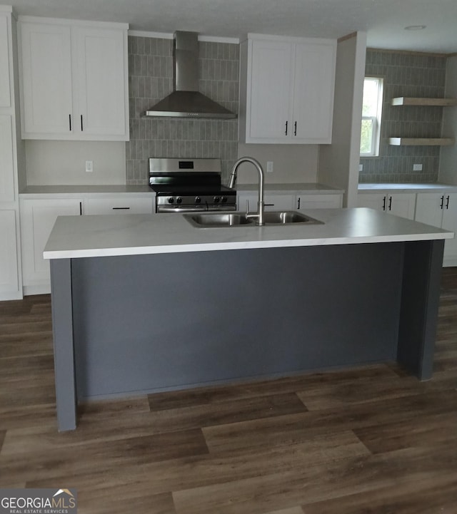 kitchen with white cabinetry, stainless steel range, wall chimney exhaust hood, and sink