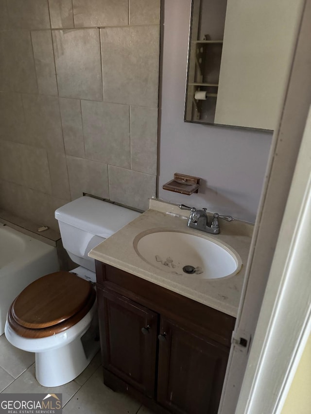 bathroom featuring vanity, tile walls, tile patterned flooring, toilet, and a tub