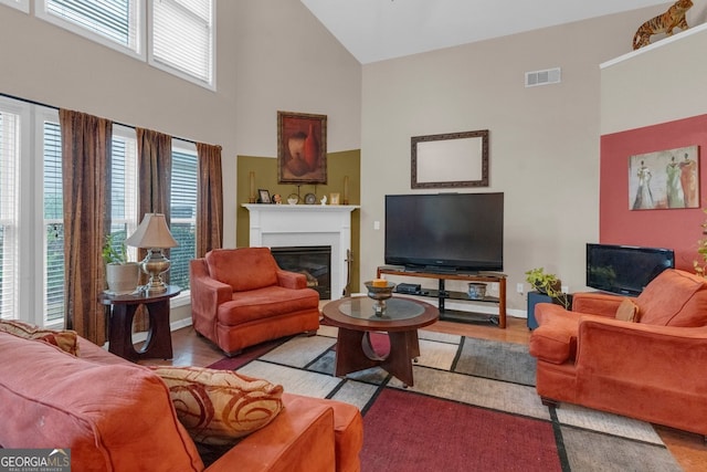 living room with light hardwood / wood-style flooring and high vaulted ceiling