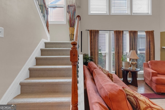 stairway featuring a wealth of natural light and hardwood / wood-style floors