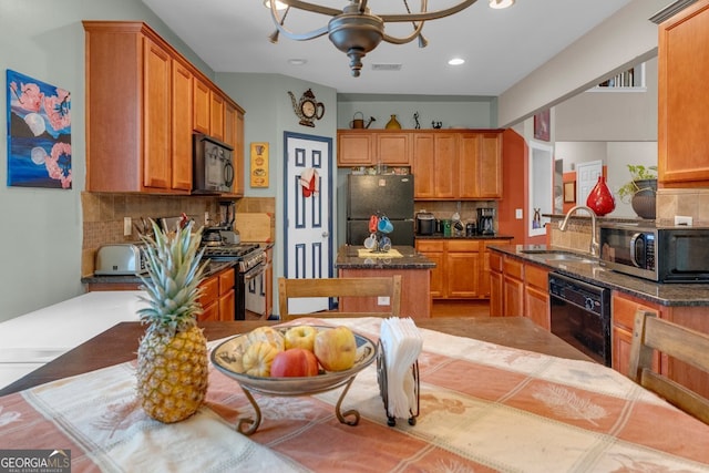 kitchen with backsplash, ceiling fan with notable chandelier, sink, black appliances, and dark stone countertops