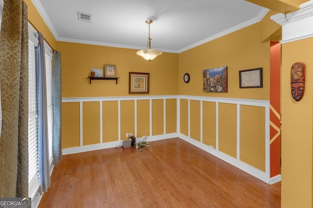 washroom with a wealth of natural light, wood-type flooring, and ornamental molding