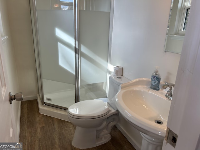 bathroom with hardwood / wood-style floors, toilet, an enclosed shower, and sink