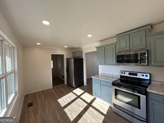 kitchen featuring crown molding, a healthy amount of sunlight, dark hardwood / wood-style flooring, and stainless steel appliances