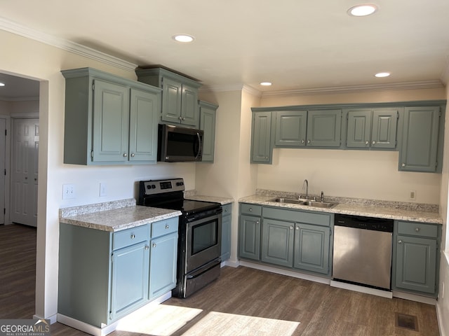 kitchen featuring dark hardwood / wood-style flooring, ornamental molding, sink, and appliances with stainless steel finishes