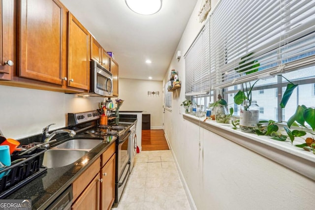 kitchen with dark stone countertops, sink, and appliances with stainless steel finishes