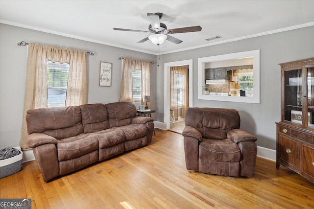 living room with light wood-type flooring, ceiling fan, and crown molding