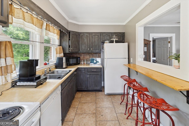 kitchen featuring decorative backsplash, ornamental molding, dark brown cabinets, white appliances, and sink