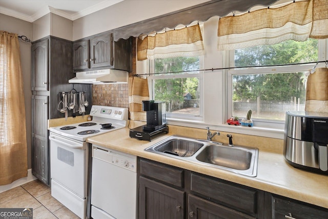 kitchen featuring tasteful backsplash, dark brown cabinets, white appliances, sink, and light tile patterned flooring