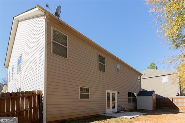 rear view of house with french doors, a patio, and a storage shed