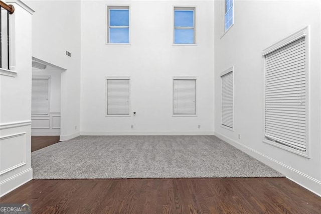 interior space with dark wood-type flooring and a high ceiling