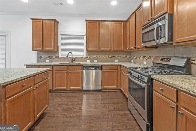 kitchen featuring dark wood-type flooring, light stone countertops, sink, and stainless steel appliances