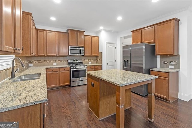 kitchen with dark hardwood / wood-style flooring, tasteful backsplash, stainless steel appliances, sink, and a kitchen island