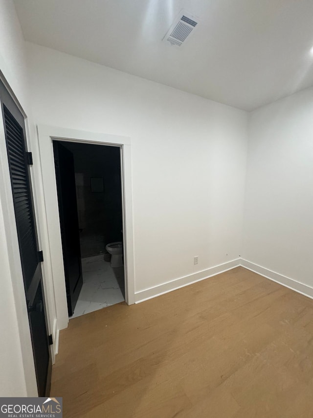 spare room with baseboards, visible vents, and light wood-type flooring