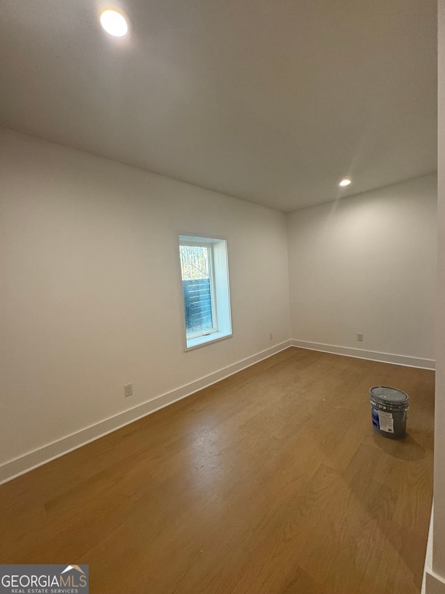 empty room featuring baseboards, wood finished floors, and recessed lighting