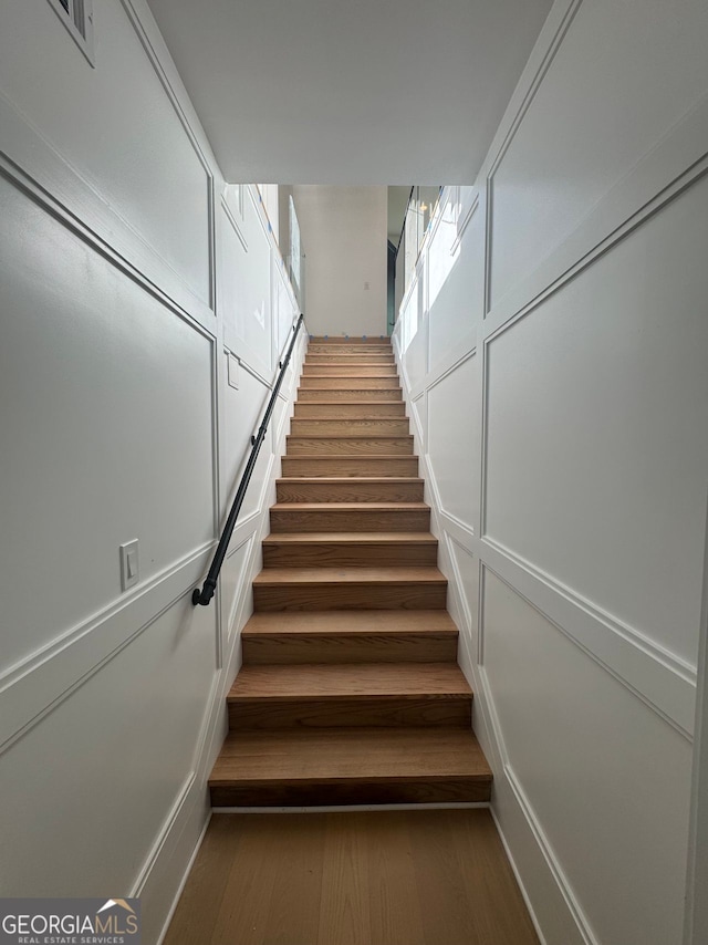 staircase with visible vents and wood finished floors