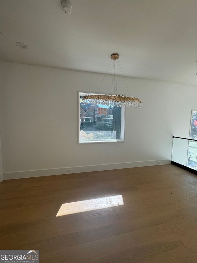 unfurnished room featuring baseboards and wood finished floors