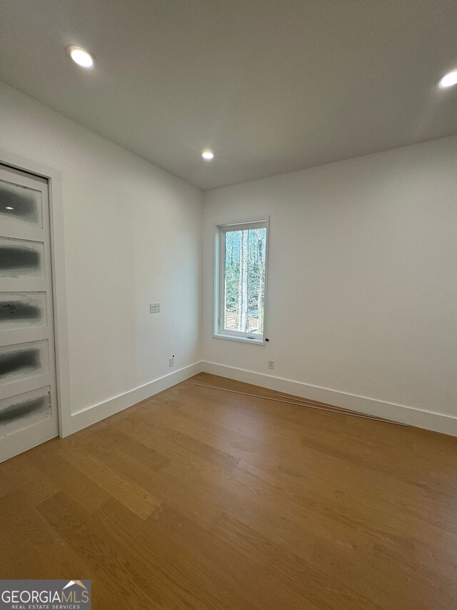 unfurnished room featuring baseboards, recessed lighting, and light wood finished floors