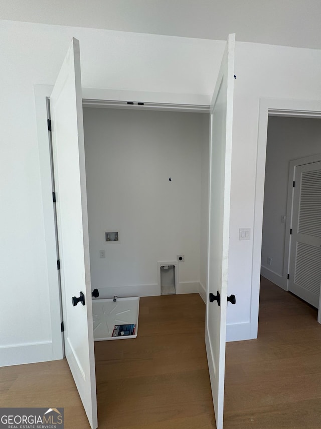 laundry room with electric dryer hookup, hookup for a washing machine, baseboards, and wood finished floors