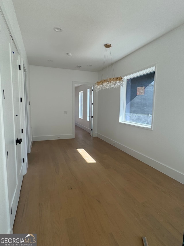 unfurnished room featuring visible vents, baseboards, and wood finished floors