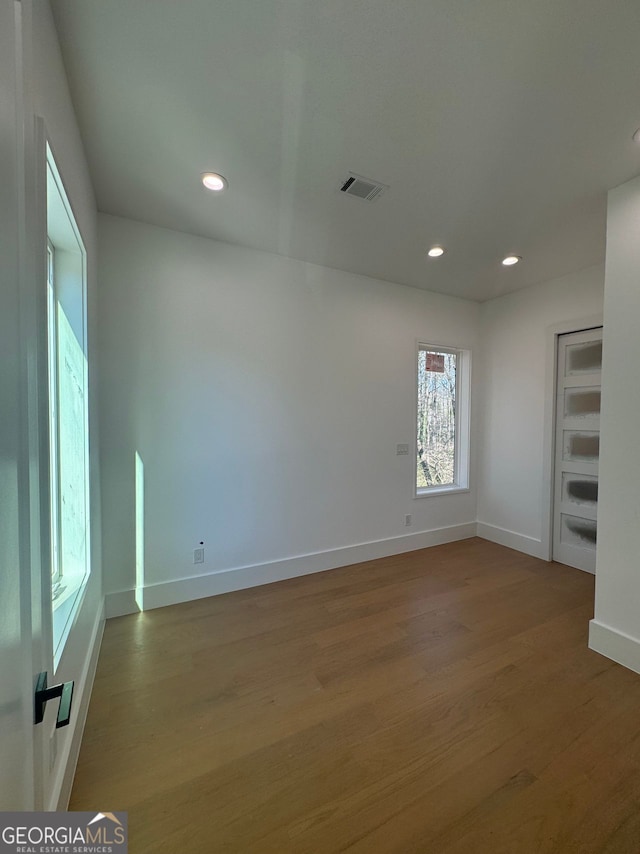 unfurnished room featuring baseboards, visible vents, recessed lighting, and wood finished floors