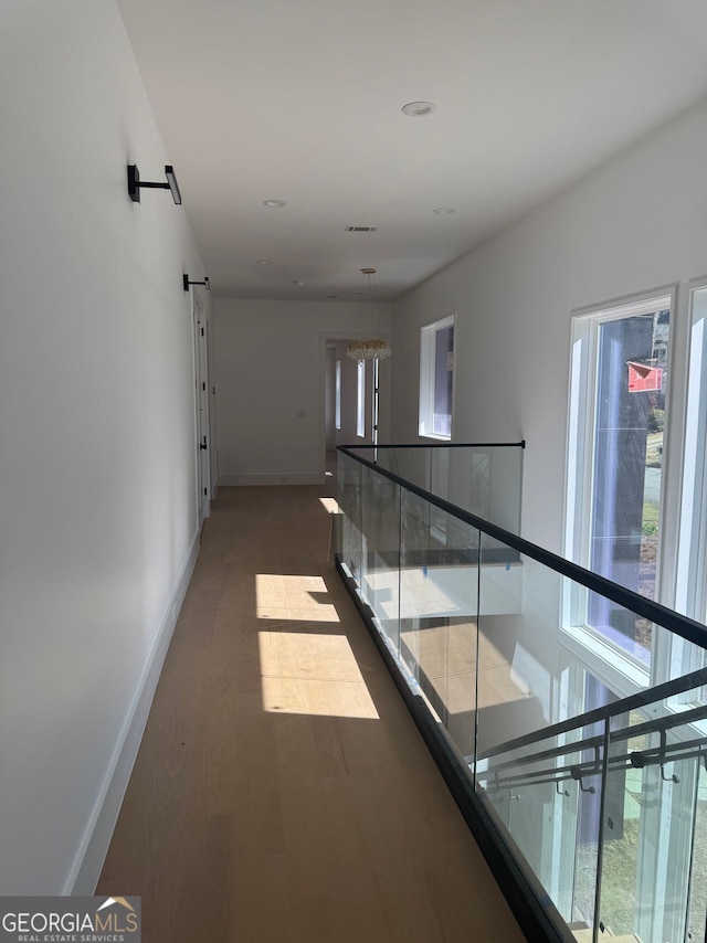 corridor with an upstairs landing, dark wood-style floors, and baseboards