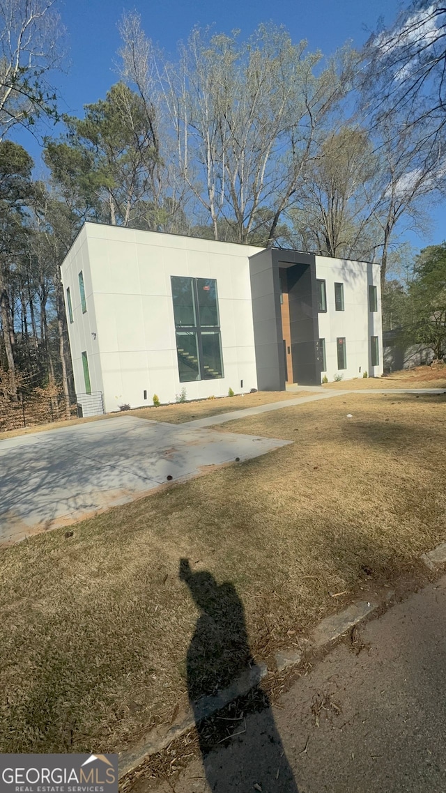 view of front of home featuring a front yard and stucco siding
